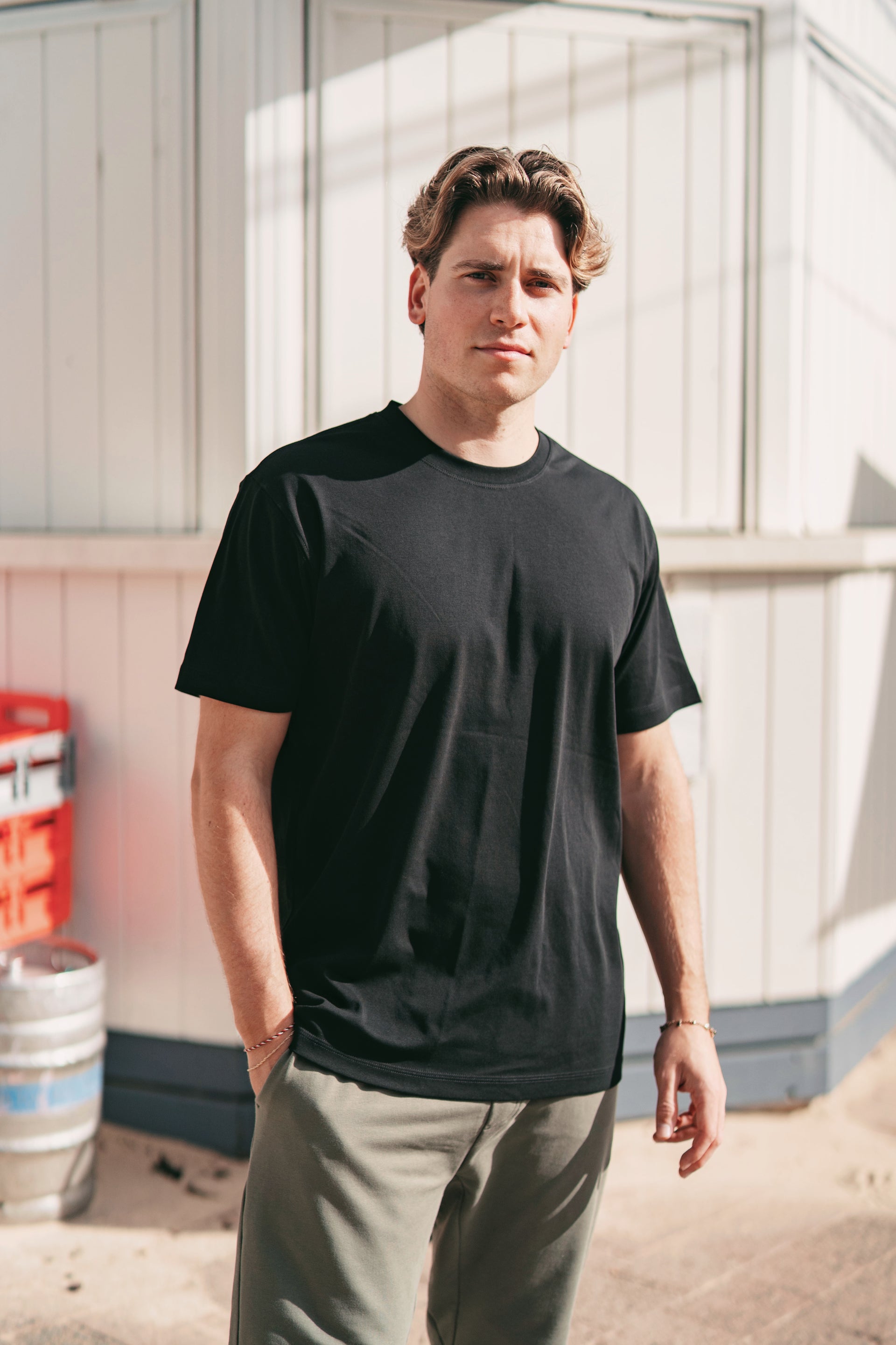 Men's black Premium Heavyweight Cotton T-Shirt front view on model, showing full fit from crew neck to hip