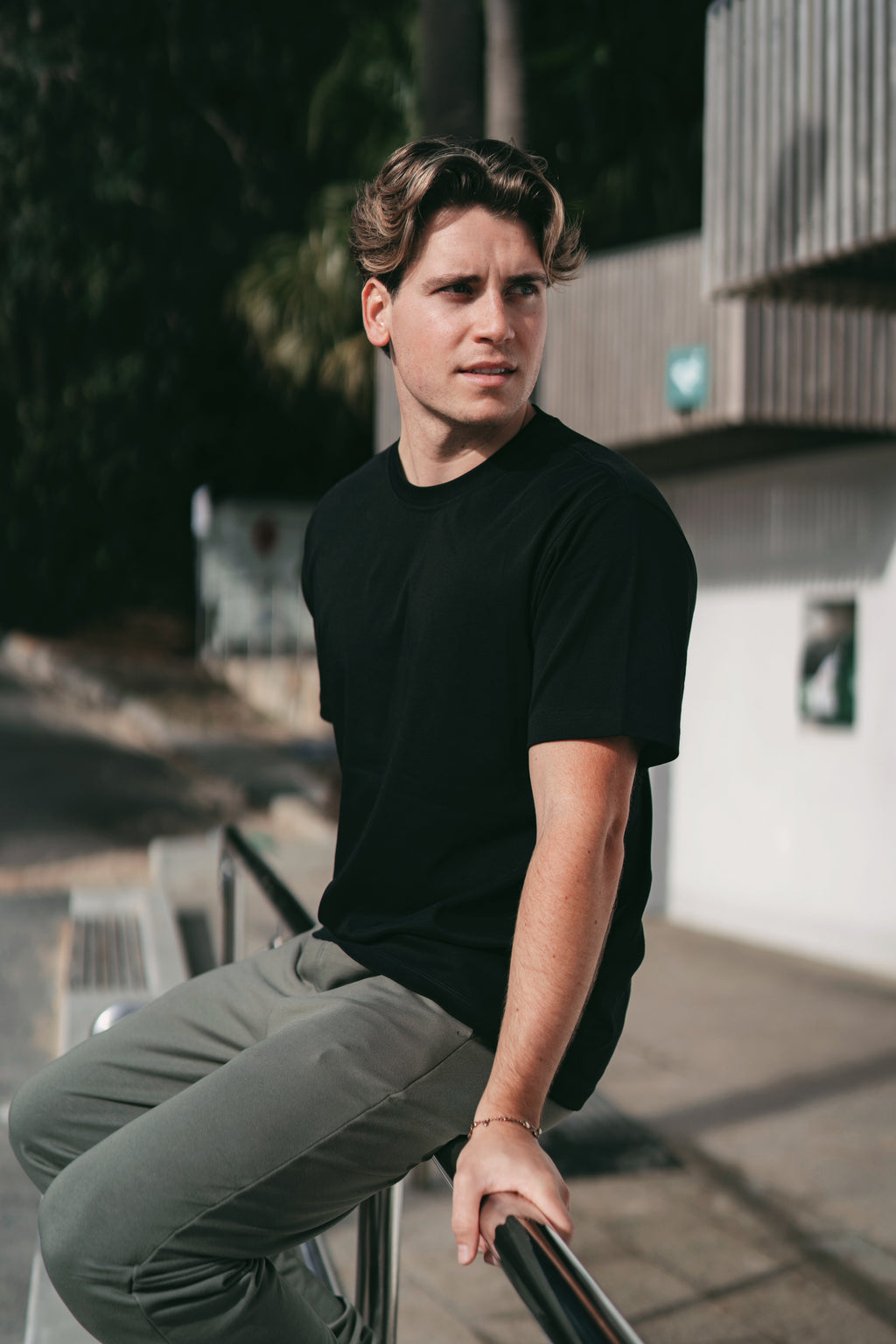 Men's black Premium Heavyweight Cotton T-Shirt side view, showing interlock double-knit fabric drape and body length